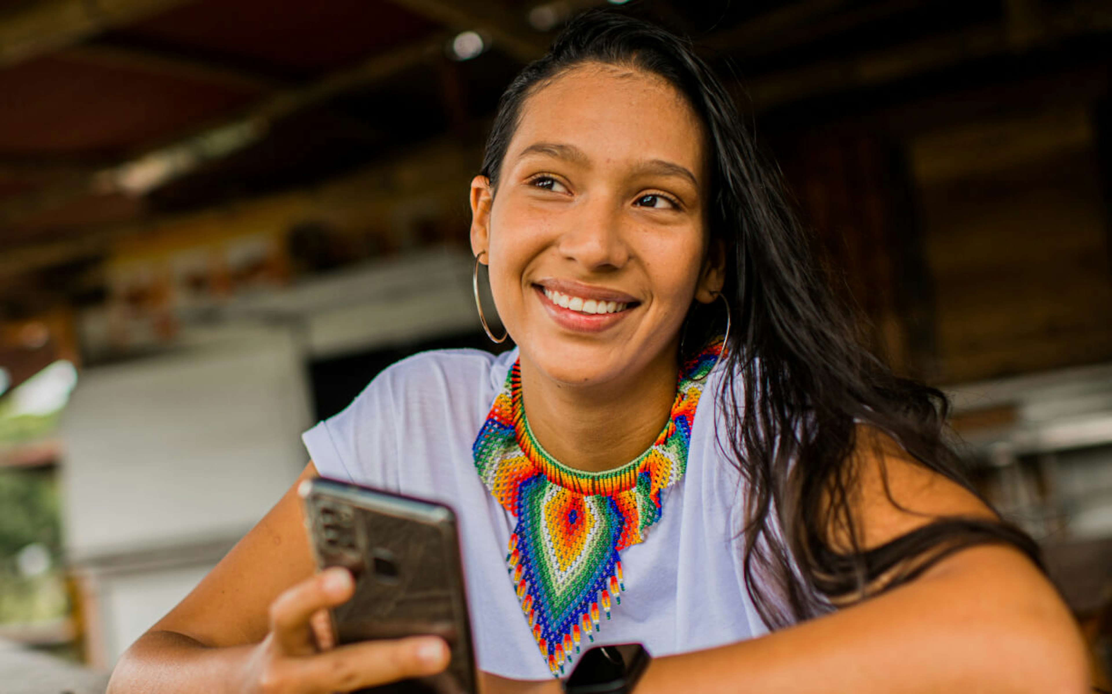 Latin woman holding a cellphone.